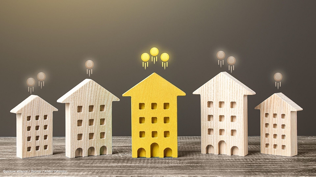 Image Description: Five miniature wooden house models on a weathered wood surface. Four houses are natural light wood, while the central house is bright yellow, making it stand out. Each house has grid-pattern windows and arched doorways. Small glowing orbs float above each house - three bright yellow orbs above the yellow house, and one or two tan orbs above the others. The composition suggests themes of home selection or finding a special property.
